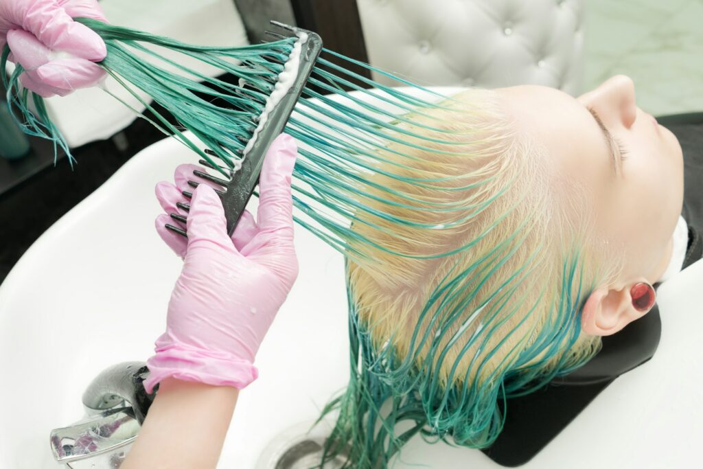 Hairdresser Holding Wet Hair in Hand and Brushes Long Green Hair While Washing Head in Shower