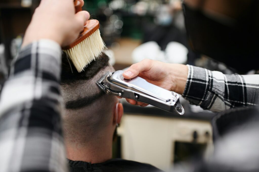 Rear view of man client visiting haidresser in barber shop